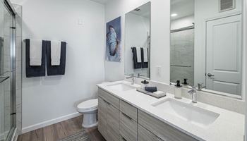 A bathroom with two sinks and a shower and a toilet
